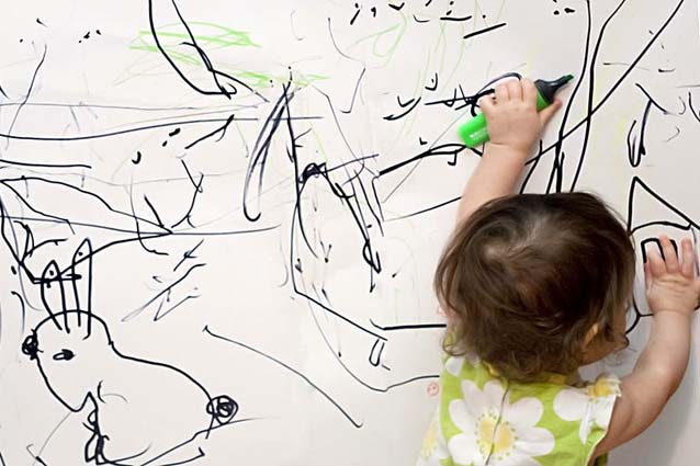 Ребенок рисует на обоях
